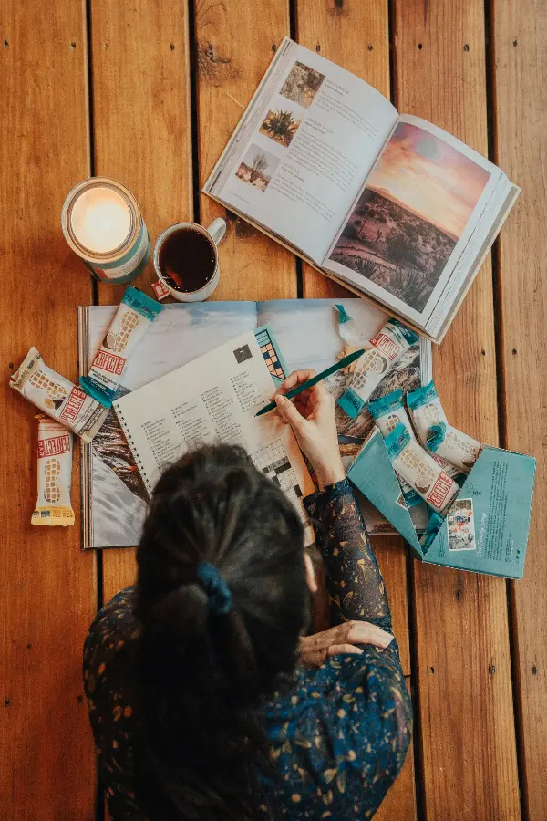 Mujer tomando notas a partir de la información de un libro de viajes.