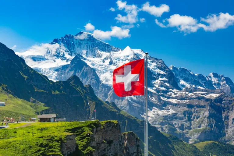 ondear-la-bandera-suiza-y-los-turistas-admiran-los-picos-de-la-montana-jungfrau-en-un-mirador-de-mannlichen-en-el-oberland-bernes-en-suiza
