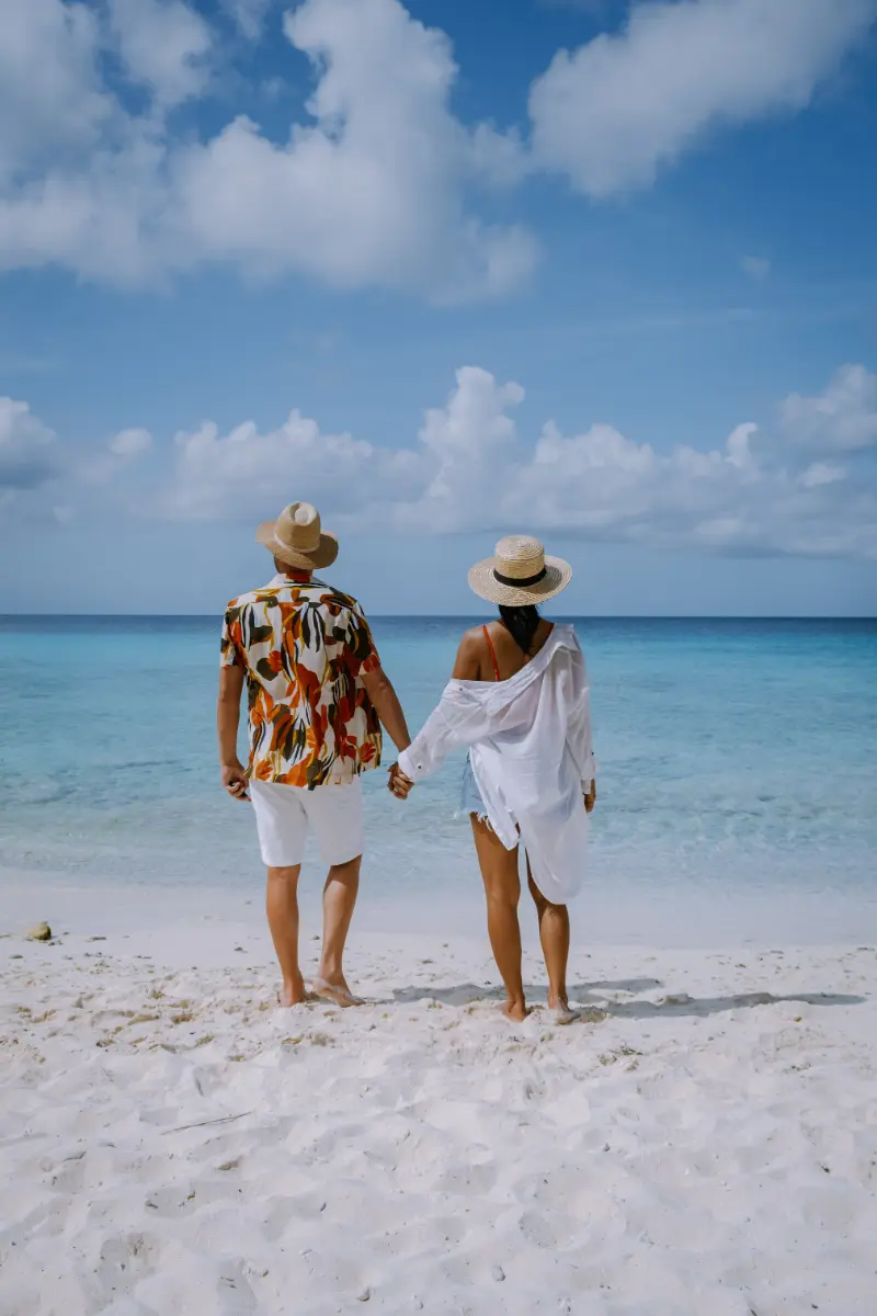 vista-trasera-de-las-mujeres-de-pie-en-la-playa-contra-el-cielo-azul